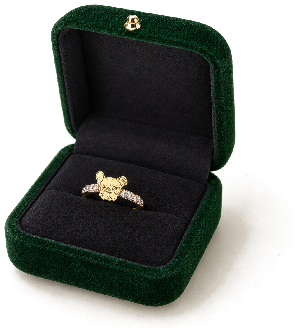 An open forest green velvet keepsake box with a dark velvet interior, holding a gold pet portrait ring set with small stones